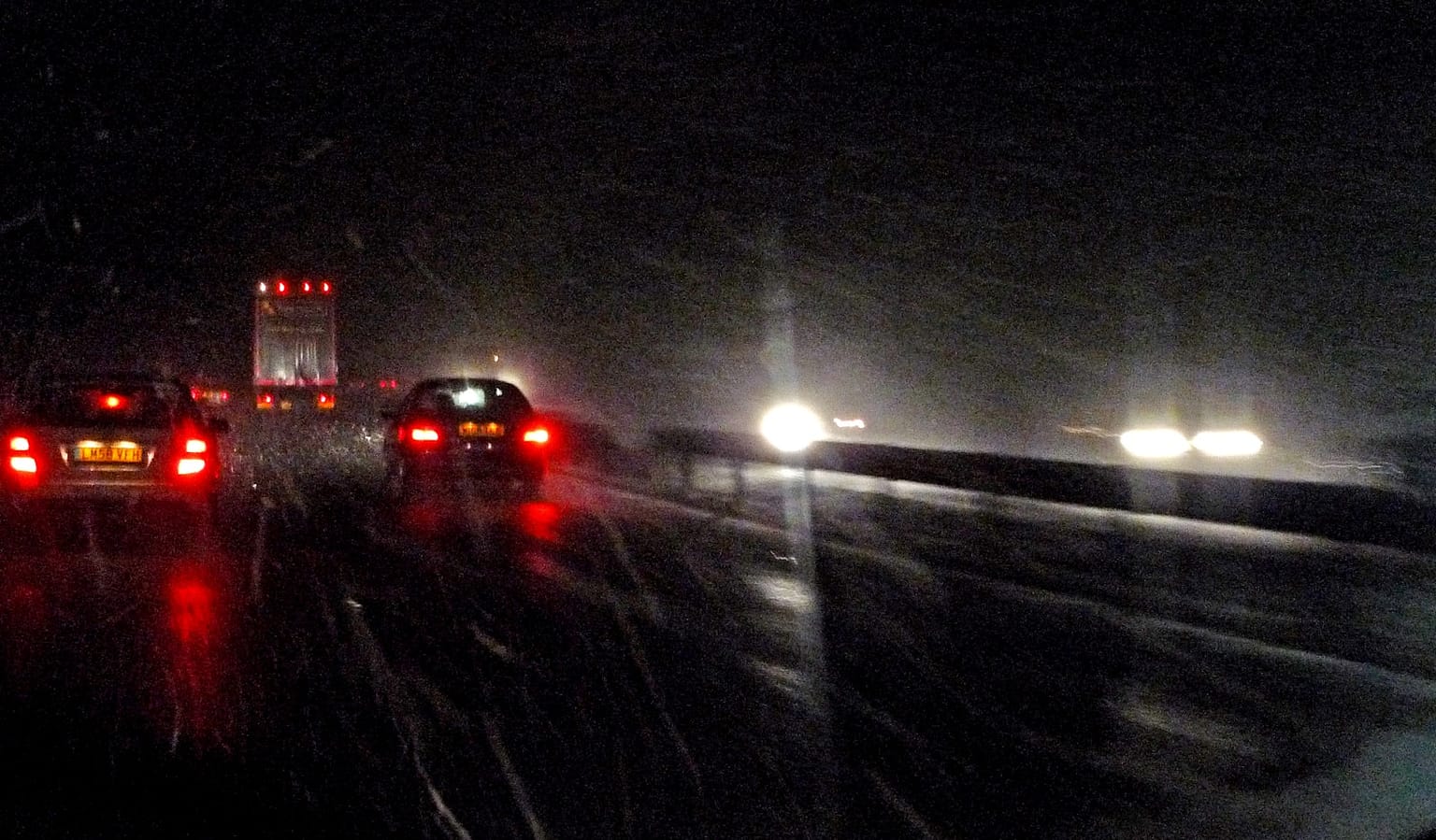 Cars driving on a wet road at night